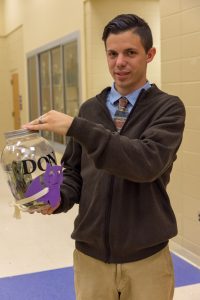 Be the Village President Joseph Deason holds the money jar prior to counting it on Saturday night.